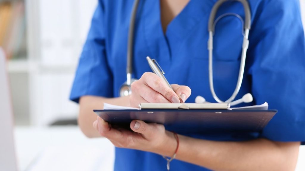 sairaanhoitaja tekemässä muistiinpanoja